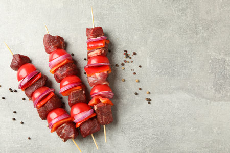 Skewers with raw shish kebab on gray backgroundの写真素材
