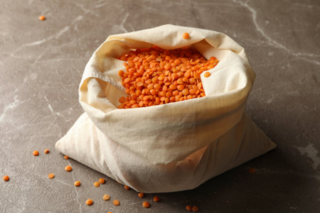 Bag with red legumes on gray background
