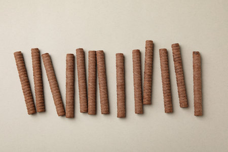 Chocolate wafer rolls on gray background, top view