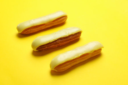 Delicious eclairs with custard on yellow backgroundの写真素材