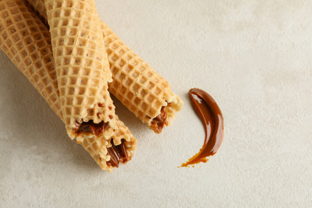 Tasty wafer rolls with condensed milk on white textured backgroundの写真素材