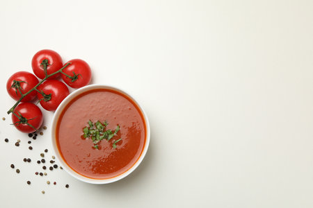 Bowl with tomato soup and ingredients on white backgroundの写真素材