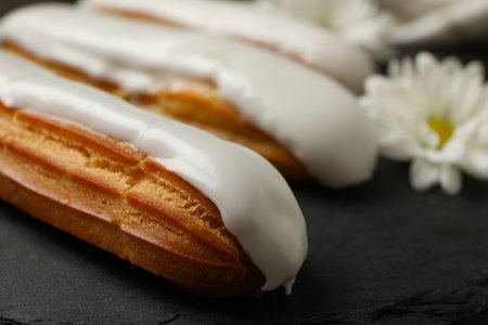 Tray with delicious eclairs and chamomile, close upの写真素材