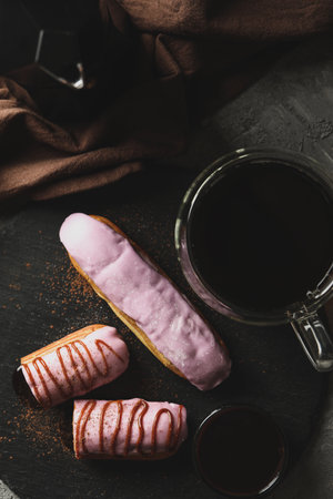 Concept of sweet meal with eclairs with delicious topping on gray backgroundの写真素材