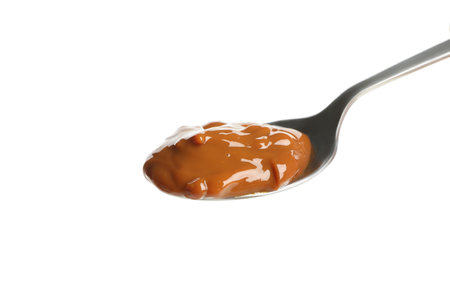 Spoon with caramel condensed milk isolated on white backgroundの写真素材