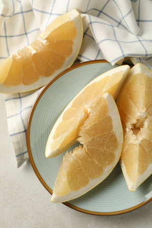 Kitchen towel and plate with pomelo slices on white textured backgroundの写真素材