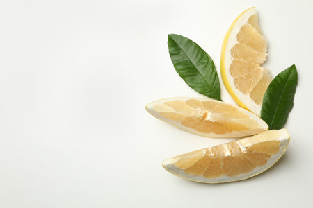 Ripe pomelo fruit slices with leaves on white backgroundの写真素材