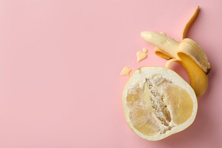 Banana and pomelo fruit with condensed milk on pink backgroundの写真素材