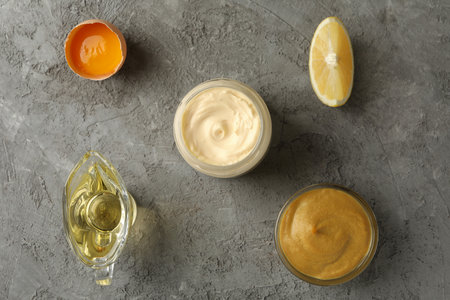 Jar with mayonnaise and ingredients for cooking on gray background, top viewの写真素材