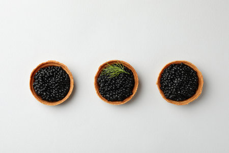 Tartlets with black caviar on white background, top viewの写真素材