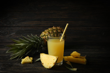 Ripe pineapple and glass of juice on wooden backgroundの写真素材