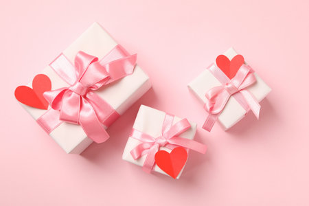Gift boxes with with decorative hearts on pink backgroundの写真素材