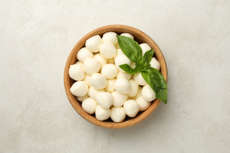 Bowl with mozzarella and basil on white textured background, top viewの写真素材