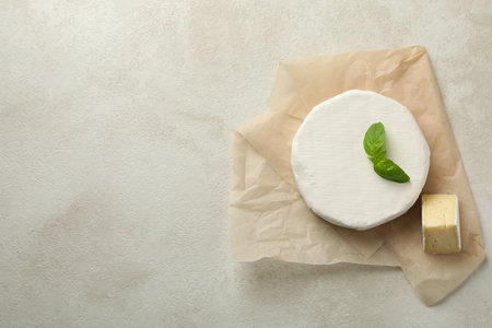 Baking paper with camembert cheese on white textured backgroundの写真素材