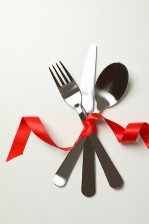 Cutlery with red ribbon on white backgroundの写真素材