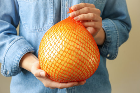 Woman hold ripe pomelo fruit, close up