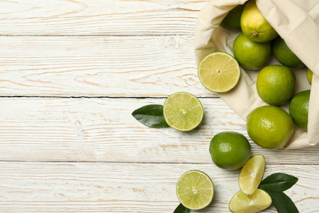 Bag with ripe lime on wooden background, space for textの写真素材