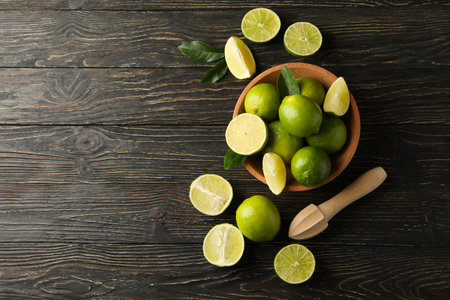 Bowl and board with lime on wooden background, top viewの写真素材
