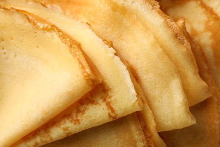 Delicious thin pancakes on whole background, close upの写真素材