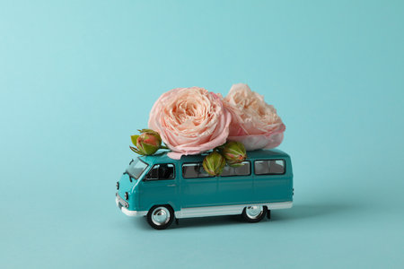 Toy bus with pink roses on blue backgroundの写真素材