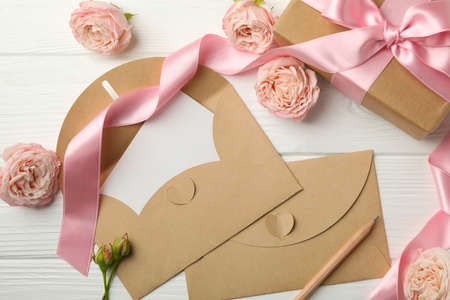 8 march concept with gift box and envelopes on white wooden background