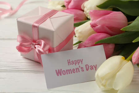 Text Happy Women's Day, tulips and gift box on white wooden background, close upの写真素材