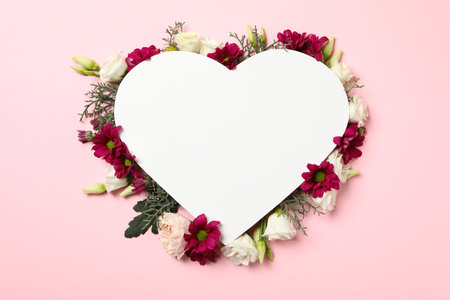 Blank heart and different flowers on pink background, space for textの写真素材