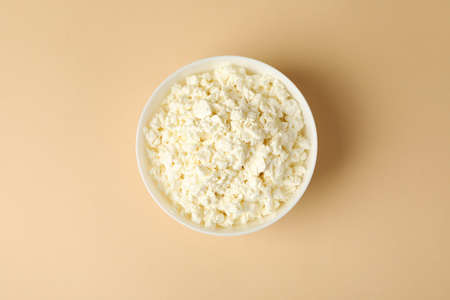Bowl with fresh cottage cheese on beige backgroundの写真素材