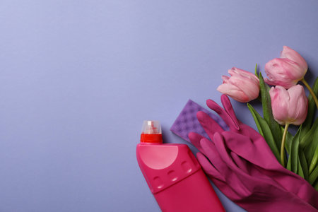 Cleaning tools and tulips on violet background, space for text