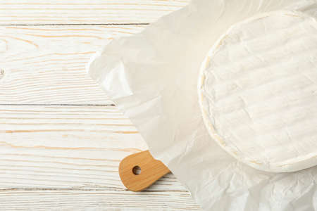 Cutting board with camembert cheese on wooden backgroundの写真素材