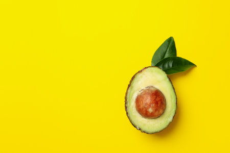 Ripe avocado on yellow background, space for textの写真素材