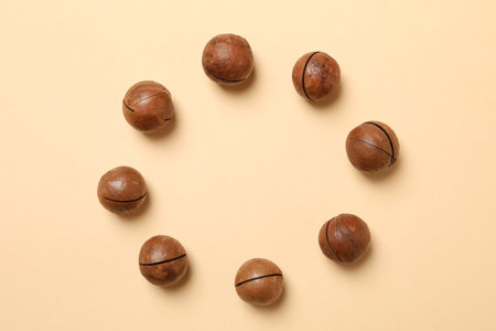 Tasty macadamia nuts on beige background, space for textの写真素材