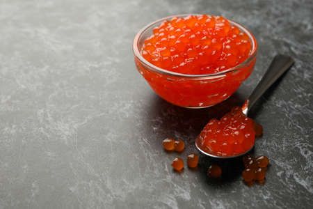 Glass bowl and spoon with caviar on black smokey backgroundの写真素材