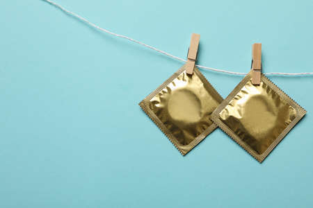 Condoms hanging on the rope on blue background