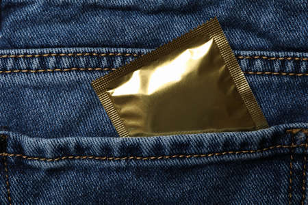 Back pocket of a jeans with condom, close upの写真素材