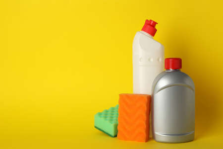 Detergents and sponges on yellow background, space for textの写真素材