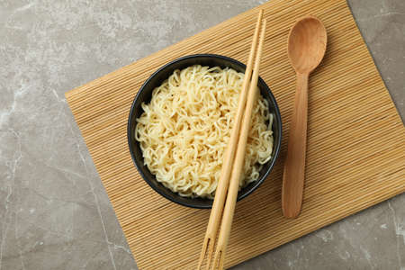 Concept of breakfast with bowl of noodles on gray backgroundの写真素材