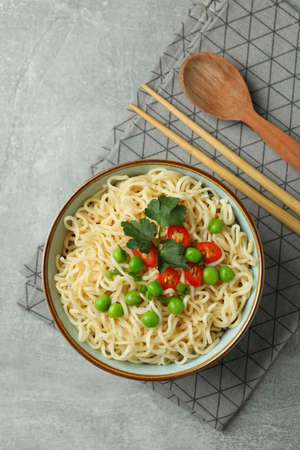 Concept of tasty eating with bowl of noodles on gray backgroundの写真素材