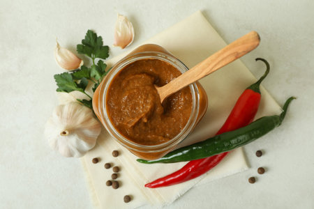 Jar with zucchini caviar on white textured table