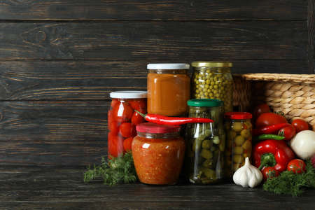 Jars with different canned food on wooden backgroundの写真素材