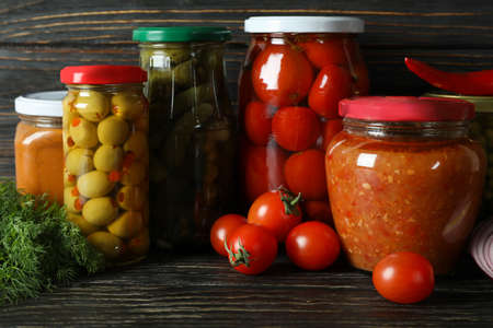 Jars with different canned food on wooden backgroundの写真素材