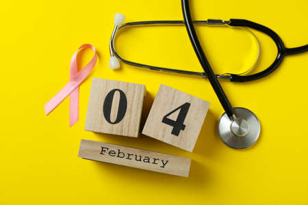 Pink awareness ribbon, stethoscope and 4 february on yellow backgroundの写真素材