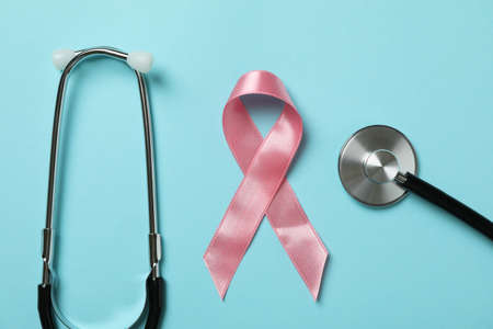 Pink awareness ribbon and stethoscope on blue backgroundの写真素材