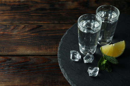 Tray with shots of vodka on wooden backgroundの写真素材