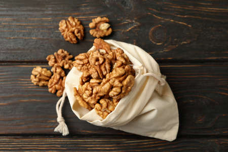 Cotton bag with tasty walnuts on wooden backgroundの写真素材