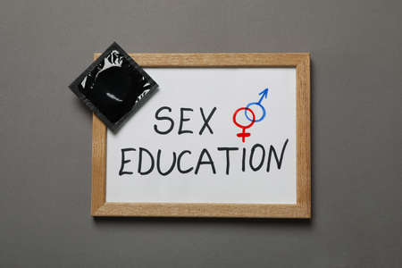 Chalkboard with text Sex Education and condom on gray background