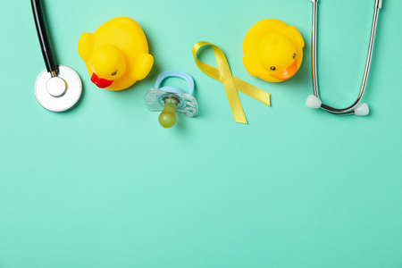 Concept of childhood cancer with awareness ribbon and accessories on mint backgroundの写真素材