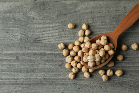 Spoon with fresh chickpea on gray textured backgroundの写真素材