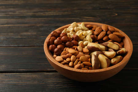 Bowl with different nuts on wooden backgroundの写真素材