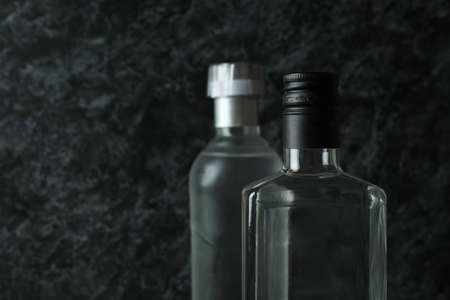 Blank bottles of vodka on black smokey background, space for textの写真素材
